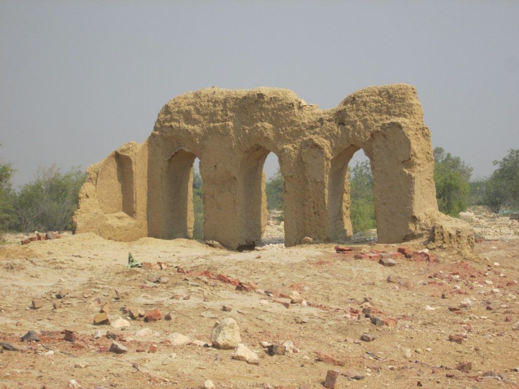 View of structure with three arches constructed with mud

